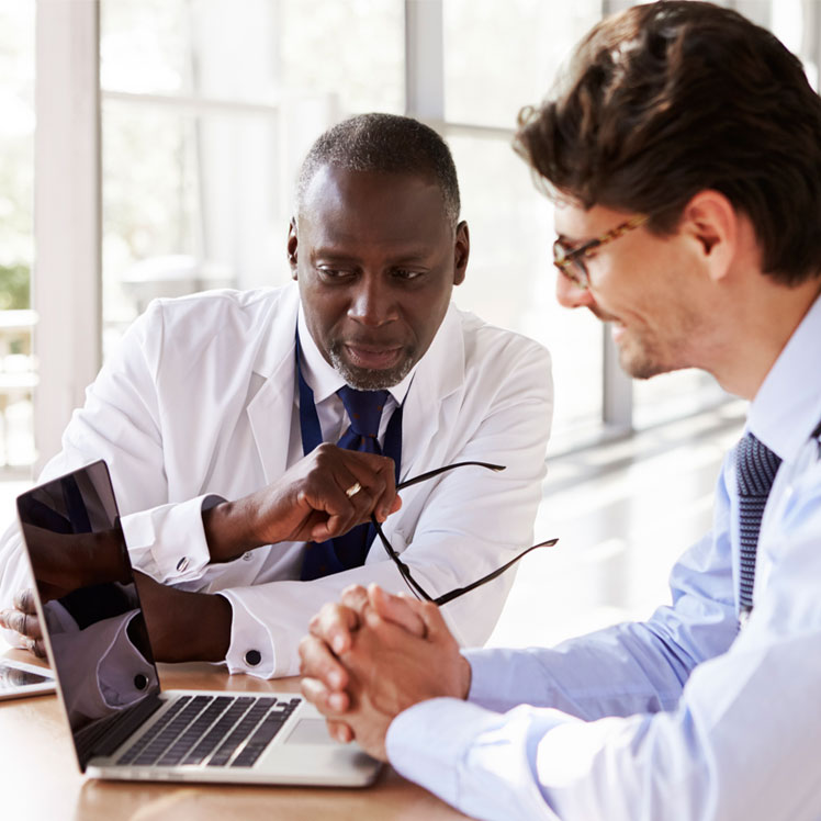 Doctors consulting at laptop